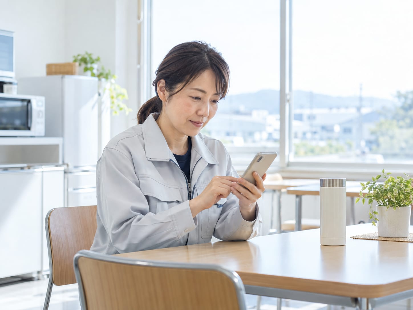 休憩時間にスマートフォンでストレスチェックに回答する従業員